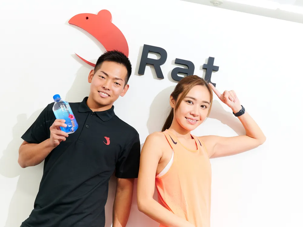 Ratロゴの前に立つトレーナー